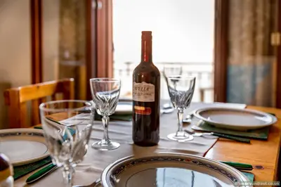a bottle of wine sitting on a table with glasses at Perla di Mare in Symi