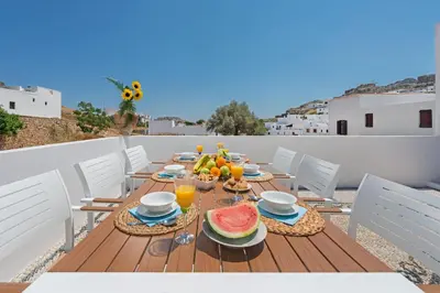 a table with food and fruit on a balcony at Lindos Diamond Exclusive Villa in Líndos