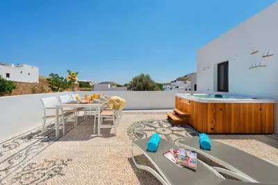 a patio with a table and chairs on a roof at Lindos Diamond Exclusive Villa in Líndos