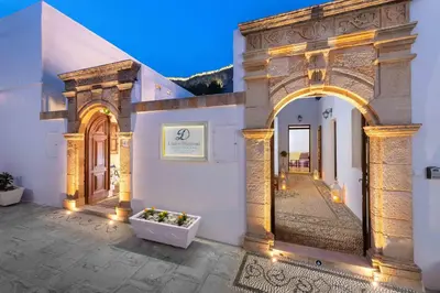 a building with an arch and a flower pot on a courtyard at Lindos Diamond Exclusive Villa in Líndos