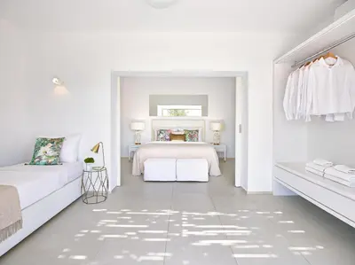 a white bedroom with a bed and a white couch at Grecotel LUXME Dama Dama in Faliraki