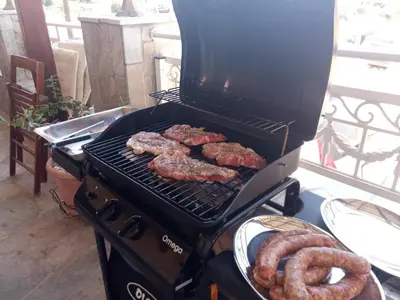 a grill with meat and pretzels on it at Arch Villa in Phanaes