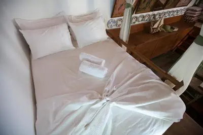 a white bed with a towel on top of it at Arch Villa in Phanaes