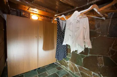 a room with a stone wall with clothes hanging on a rack at Arch Villa in Phanaes