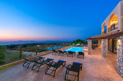 a villa with a swimming pool and some chairs at Butterfly Villa with stunning Sea and Valley Views in Theologos