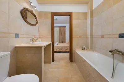 a bathroom with a tub and a sink and a toilet at Butterfly Villa with stunning Sea and Valley Views in Theologos