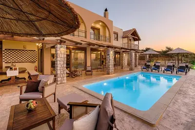 an indoor pool with chairs and a house at Butterfly Villa with stunning Sea and Valley Views in Theologos