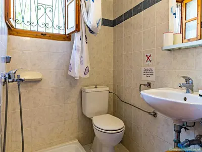 a bathroom with a toilet and a sink at Fotinis Cottage in Symi