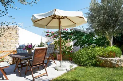 a patio with a table and an umbrella at Fotinis Cottage in Symi