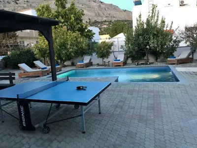 a ping pong table next to a swimming pool at Villa Amor in Pefki Rhodes