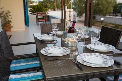 a wooden table with a bottle of wine and glasses at Villa Amor in Pefki Rhodes