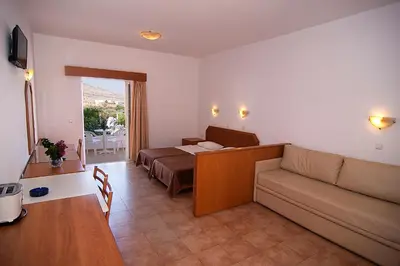 a living room with a couch and a bed at Lambis Studios & Apartments in Líndos