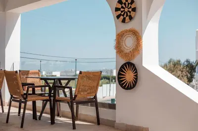 a dining room with a table and chairs on a balcony at Lambis Studios & Apartments in Líndos