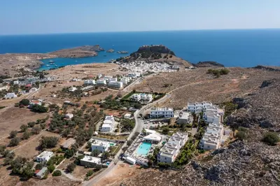 an aerial view of a village on a hill next to the ocean at Lambis Studios & Apartments in Líndos