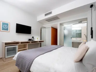 a bedroom with a large bed and a television at Athena Hotel in Rhodes Town