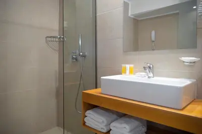 a bathroom with a sink and a shower at Athena Hotel in Rhodes Town