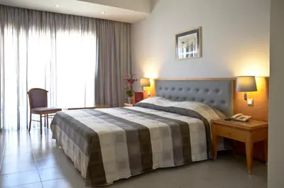 a hotel room with a bed and a table and a chair at Athena Hotel in Rhodes Town