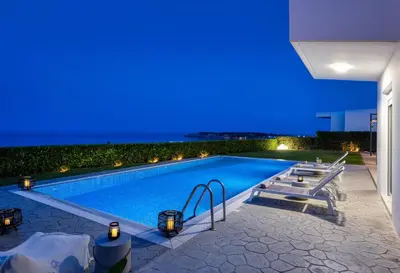 a swimming pool at night with blue lights at Hill & Sea View Villas in Kolimbia