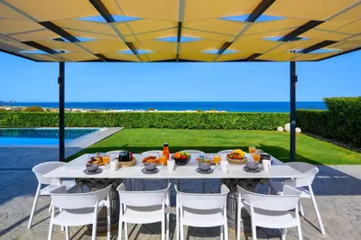 a white table with chairs and food on a patio at Hill & Sea View Villas in Kolimbia