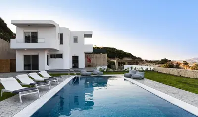 a villa with a swimming pool in front of a house at Hill & Sea View Villas in Kolimbia