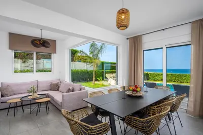 a living room with a table and chairs at Hill & Sea View Villas in Kolimbia