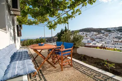 a table and chairs on the balcony of a house at CasaLindos Spitaki in Líndos