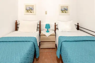 two beds in a room with blue and white at Casa Theoni in Kattavía