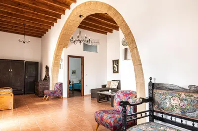a living room with an archway and chairs at Casa Theoni in Kattavía