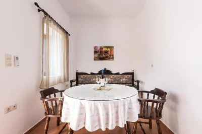 a dining room with a table with two chairs at Casa Theoni in Kattavía