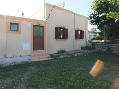 a house with a yard with a frisbee in front of it at Casa Theoni in Kattavía
