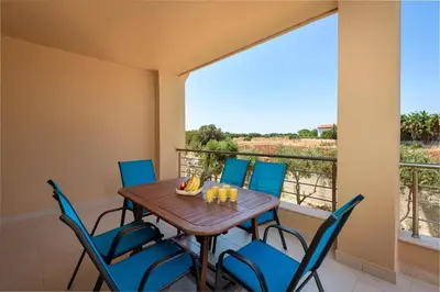 a dining room with a table and chairs and a balcony at Villa Anolia with Private Pool in Koskinou