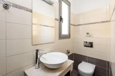 a bathroom with a sink and a toilet at Villa Anolia with Private Pool in Koskinou
