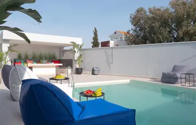 a swimming pool with a blue couch and chairs in a backyard at Villa Stergos in Kremasti