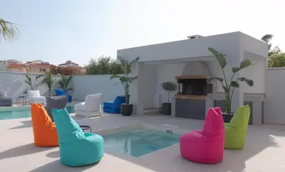 a group of colorful chairs sitting next to a pool at Villa Stergos in Kremasti