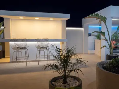 a lobby with chairs and plants and a bar at Villa Stergos in Kremasti