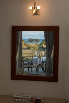 a mirror on a wall with a table and chairs at Villa Stergos in Kremasti