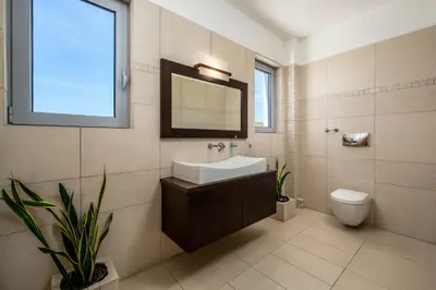 a bathroom with a sink and a toilet and a mirror at Villa Zafira - Seaview Manor with Heated Pool in Kallithea Rhodes