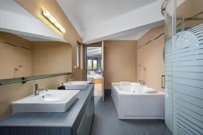 a bathroom with two sinks and a tub at Villa Zafira - Seaview Manor with Heated Pool in Kallithea Rhodes