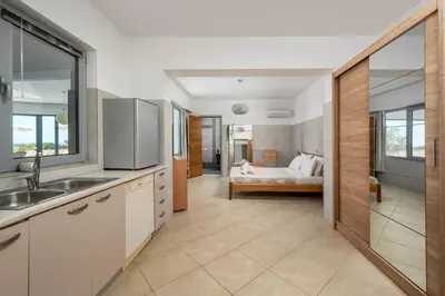a kitchen with a sink and a bed in a room at Villa Zafira - Seaview Manor with Heated Pool in Kallithea Rhodes