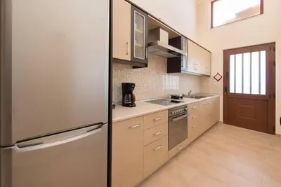 a kitchen with a stainless steel refrigerator and cabinets at Theologos Traditional House in Theologos