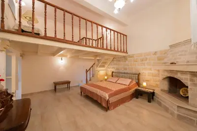 a large bedroom with a bed and a fireplace at Theologos Traditional House in Theologos