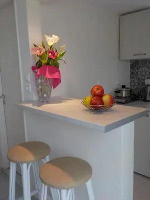 a kitchen counter with a bowl of fruit and a vase of flowers at Mini City Center Studio in Rhodes Town