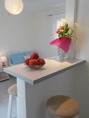 a table with a bowl of apples and a vase of flowers at Mini City Center Studio in Rhodes Town
