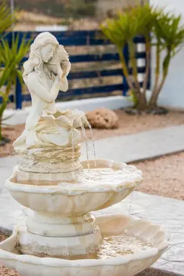 a statue of a woman sitting in a fountain at Villa Elias in Archangelos