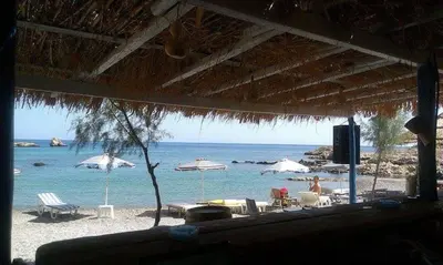 a view of a beach with chairs and umbrellas at Villa Elias in Archangelos