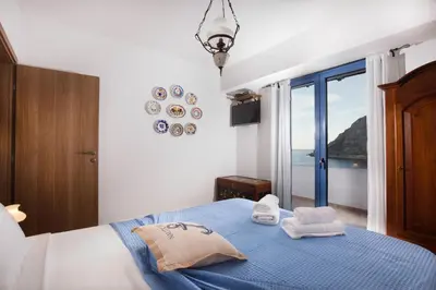 a bedroom with a blue bed with a view of the ocean at Villa Elias in Archangelos