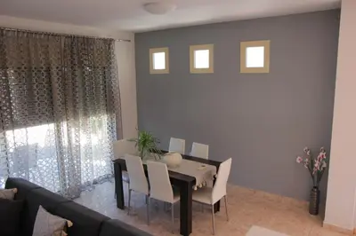 a dining room with a table and a couch at Platoni Elite in Ialyssos