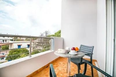 a balcony with a table and chairs and a window at Platoni Elite in Ialyssos