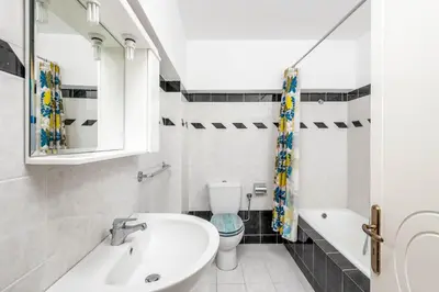 a white bathroom with a sink and a toilet at Sutherlea in Koskinou