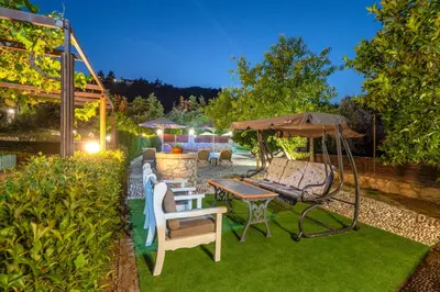 a patio with a table and chairs and an umbrella at Villa Rafaela in Koskinou